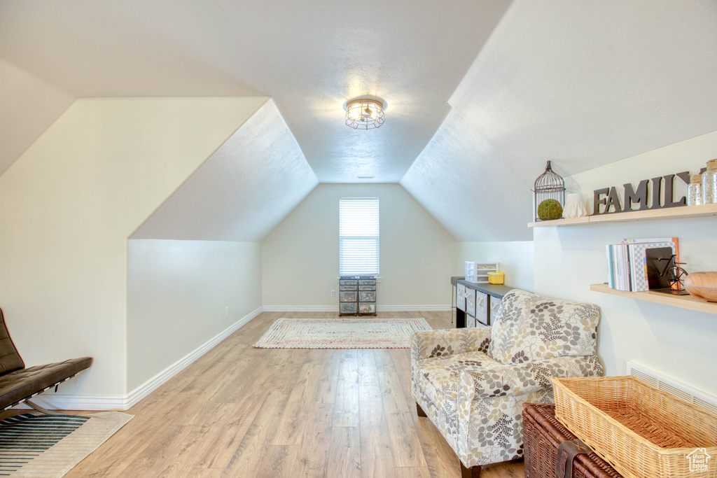 Living area featuring vaulted ceiling, wood finished floors, and baseboards