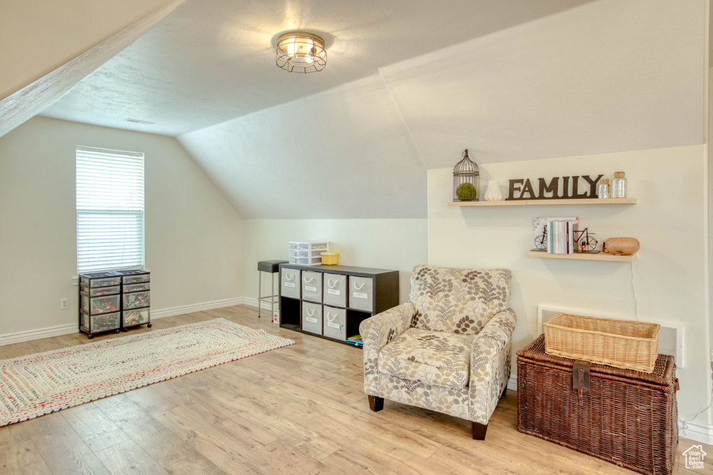 Sitting room with baseboards, wood finished floors, and vaulted ceiling