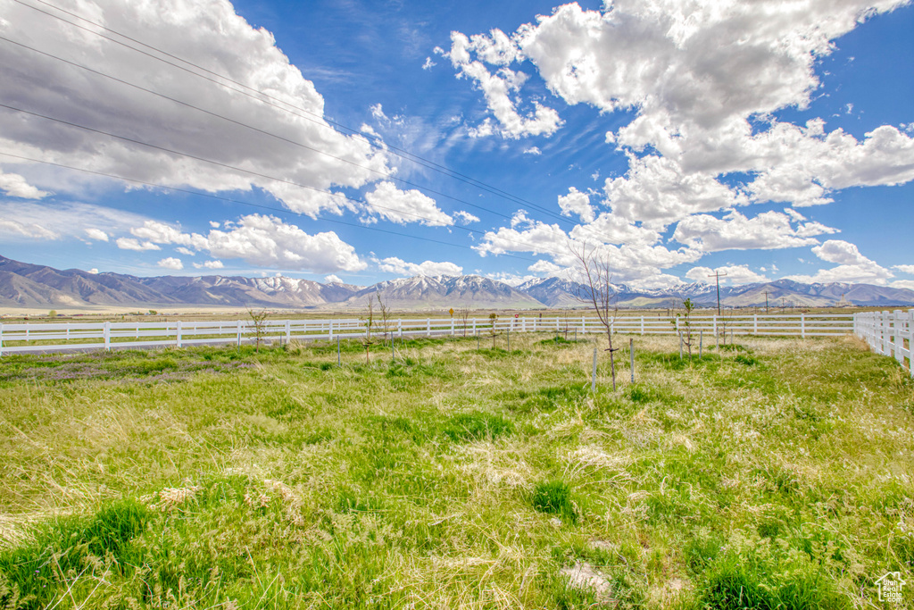 View of yard with a mountain view, a rural view, and fence