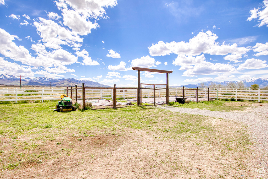 View of yard with fence, a rural view, and a mountain view