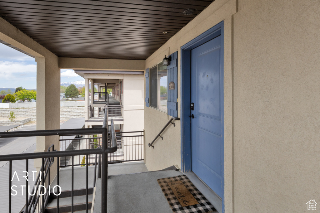 Doorway to property with stucco siding and a balcony