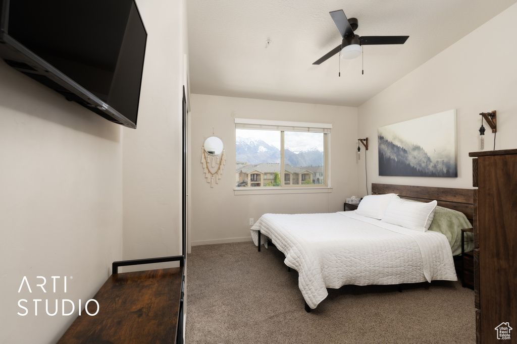 Carpeted bedroom featuring ceiling fan, lofted ceiling, and baseboards