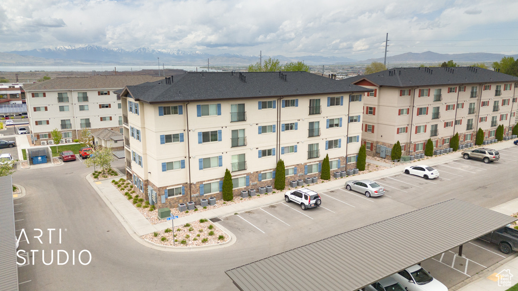 View of building exterior with uncovered parking and a mountain view