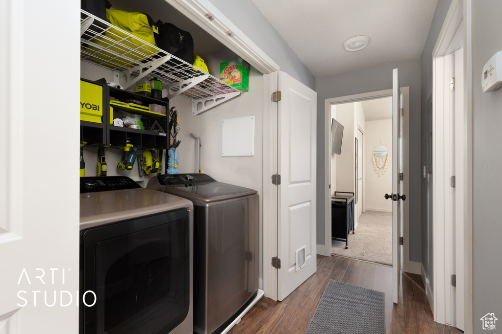 Laundry area featuring dark wood-style floors, laundry area, and washer and clothes dryer