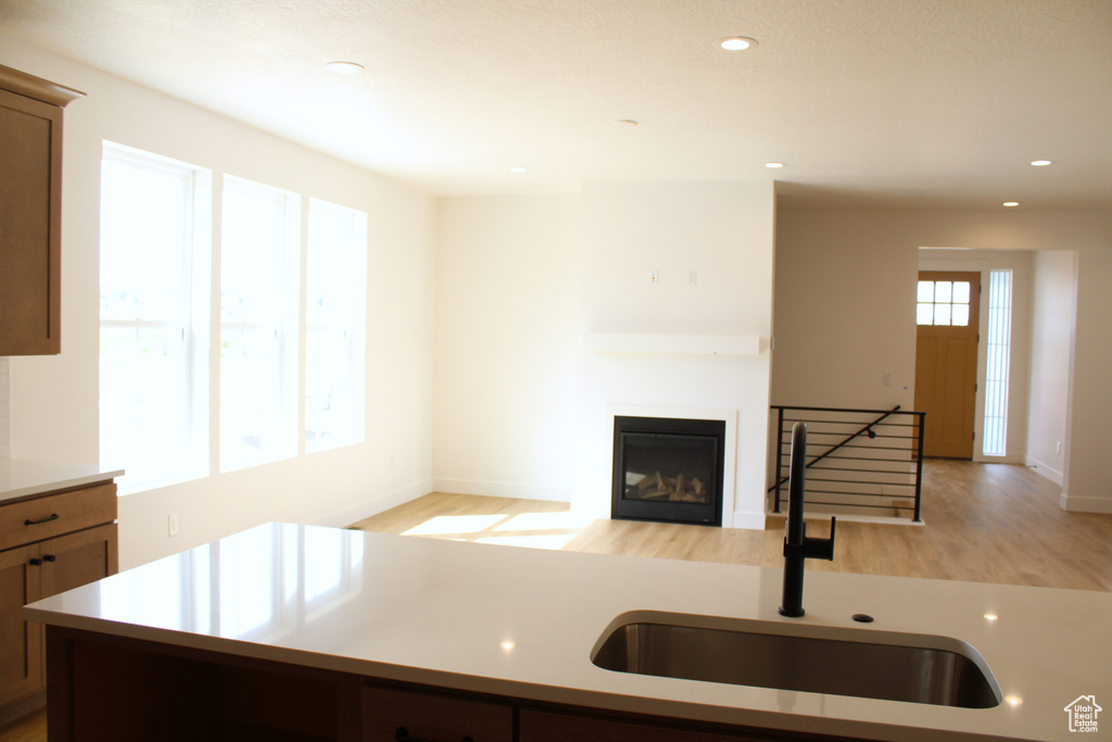 Kitchen featuring light wood finished floors, recessed lighting, a sink, and light countertops
