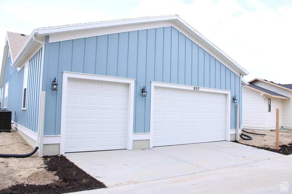 Garage with central AC unit and concrete driveway