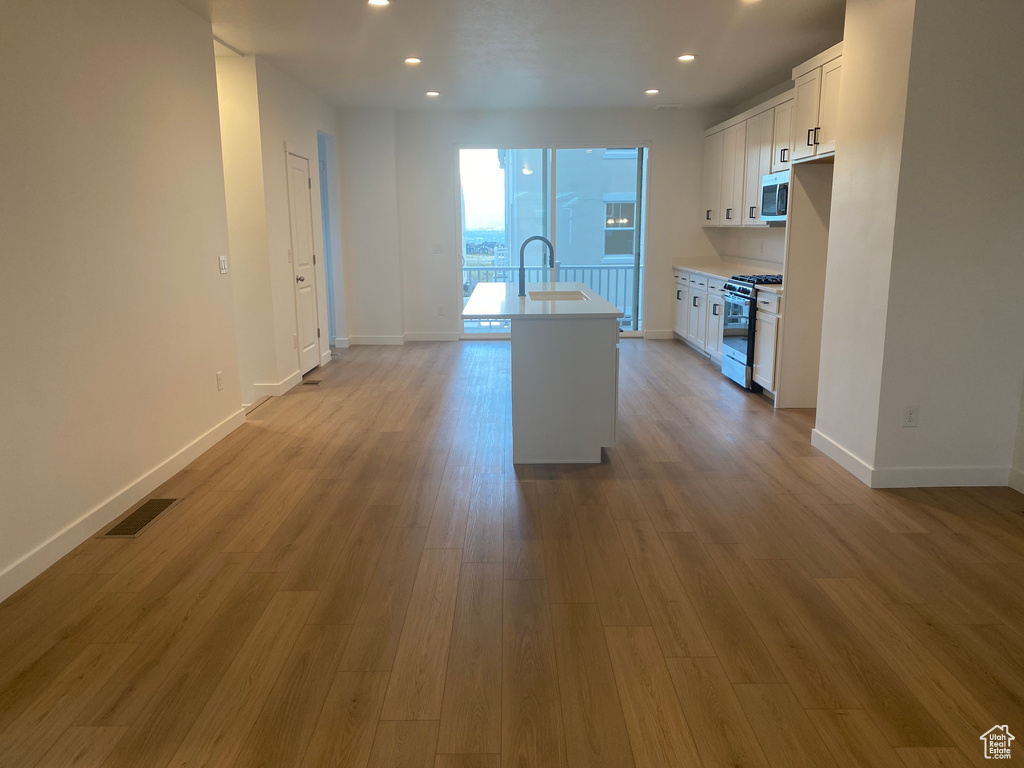 Kitchen with a sink, visible vents, light countertops, white cabinets, and appliances with stainless steel finishes