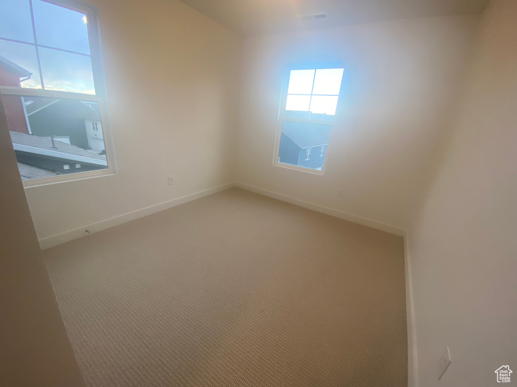 Carpeted empty room featuring baseboards