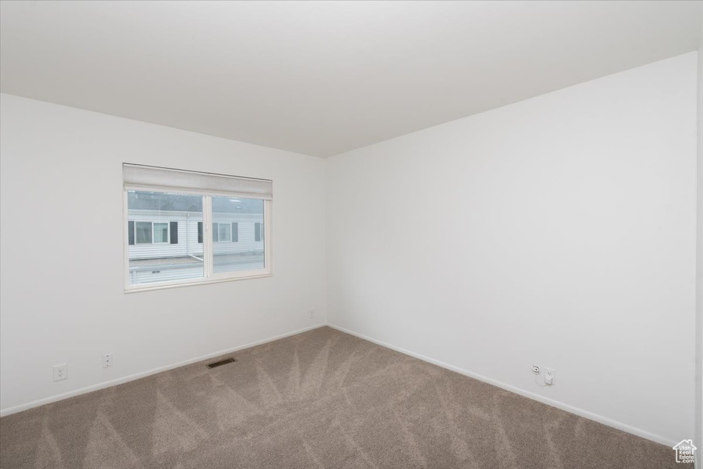 Unfurnished room with visible vents, carpet floors, and baseboards