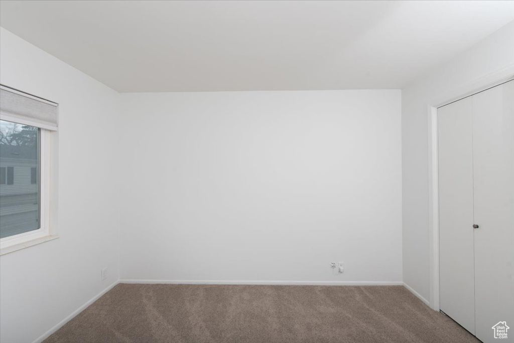 Unfurnished bedroom featuring a closet, carpet flooring, and baseboards
