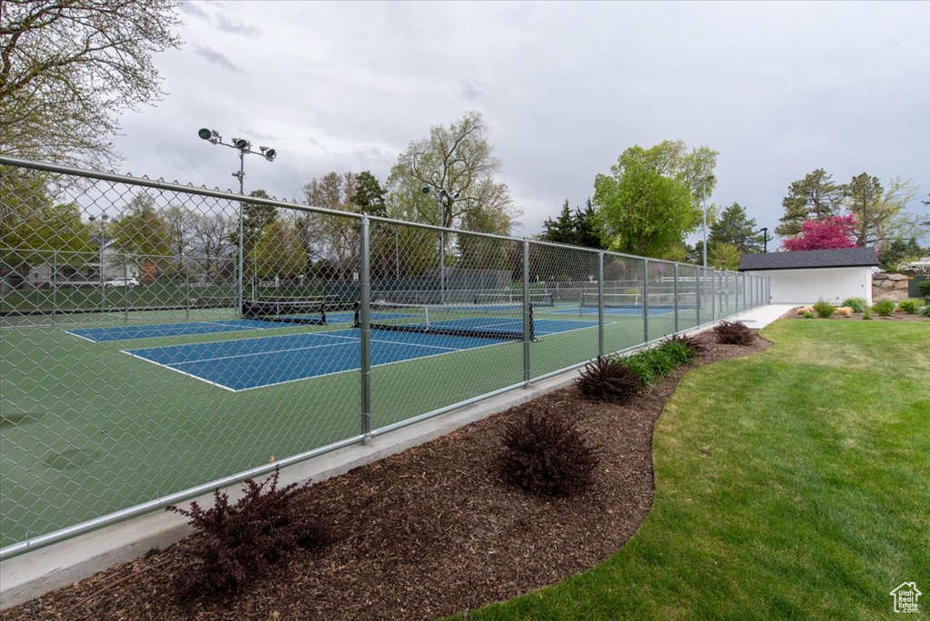 View of sport court with a lawn and fence