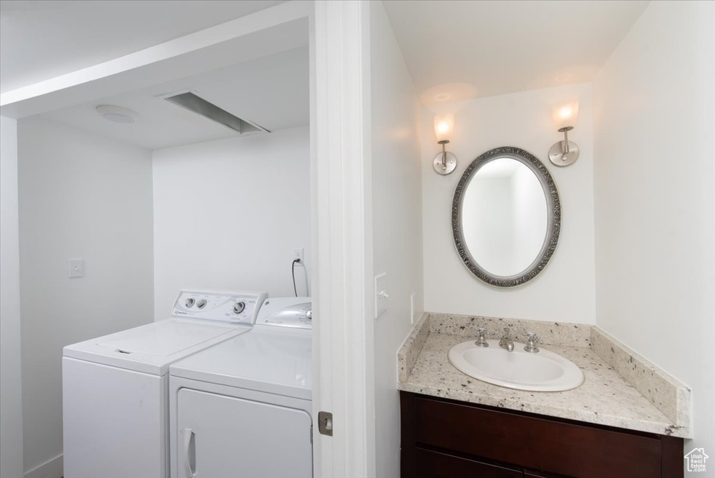 Laundry area featuring separate washer and dryer, laundry area, and a sink