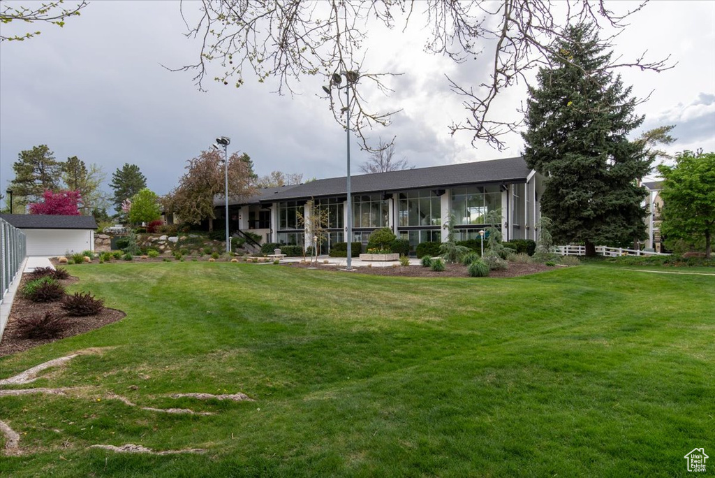 Back of house featuring fence and a yard