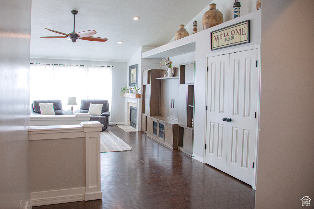 Living room featuring dark wood-style floors, recessed lighting, ceiling fan, vaulted ceiling, and baseboards