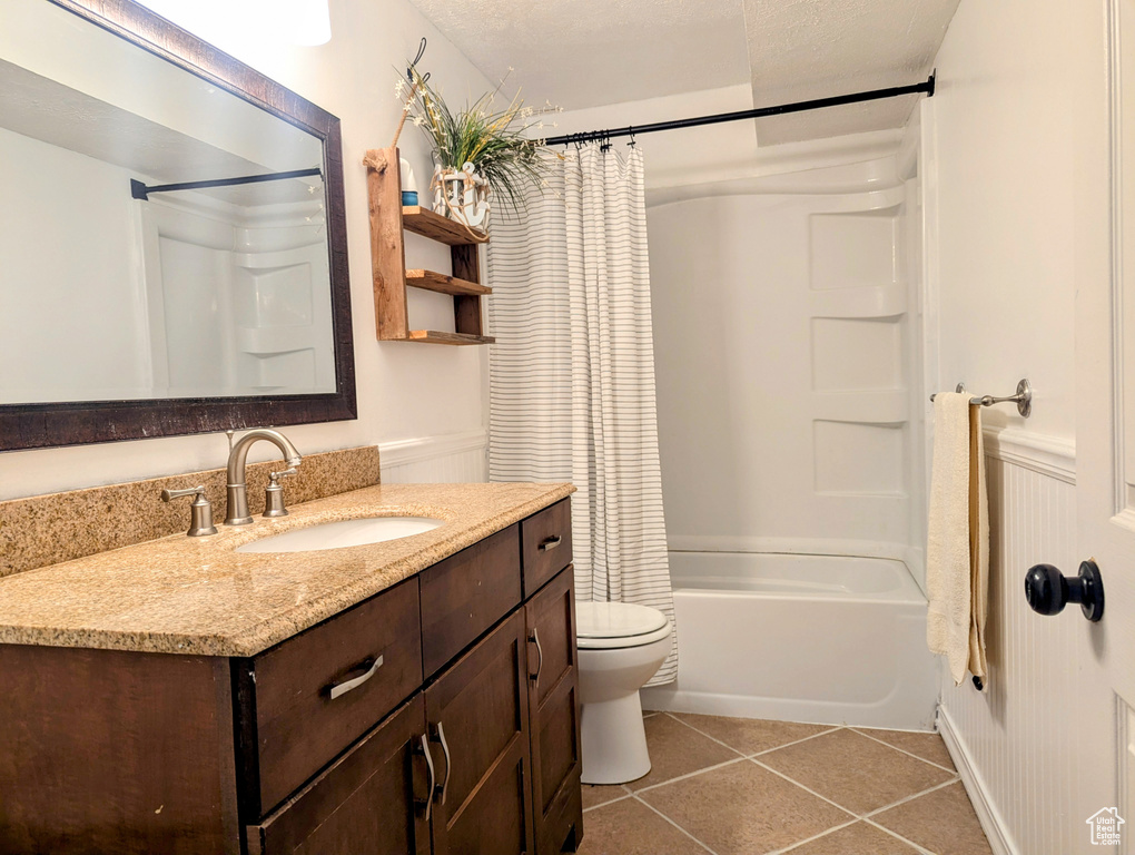 Full bathroom with vanity, toilet, tile patterned floors, and shower / bath combo