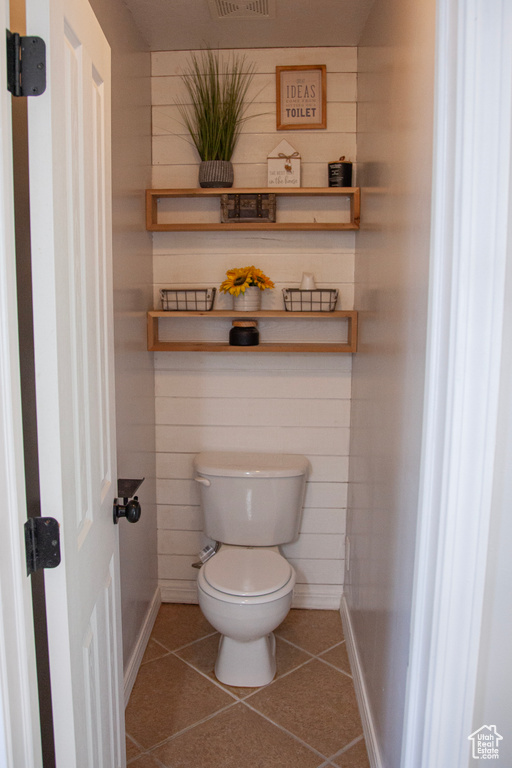 Bathroom featuring tile patterned floors, toilet, and baseboards