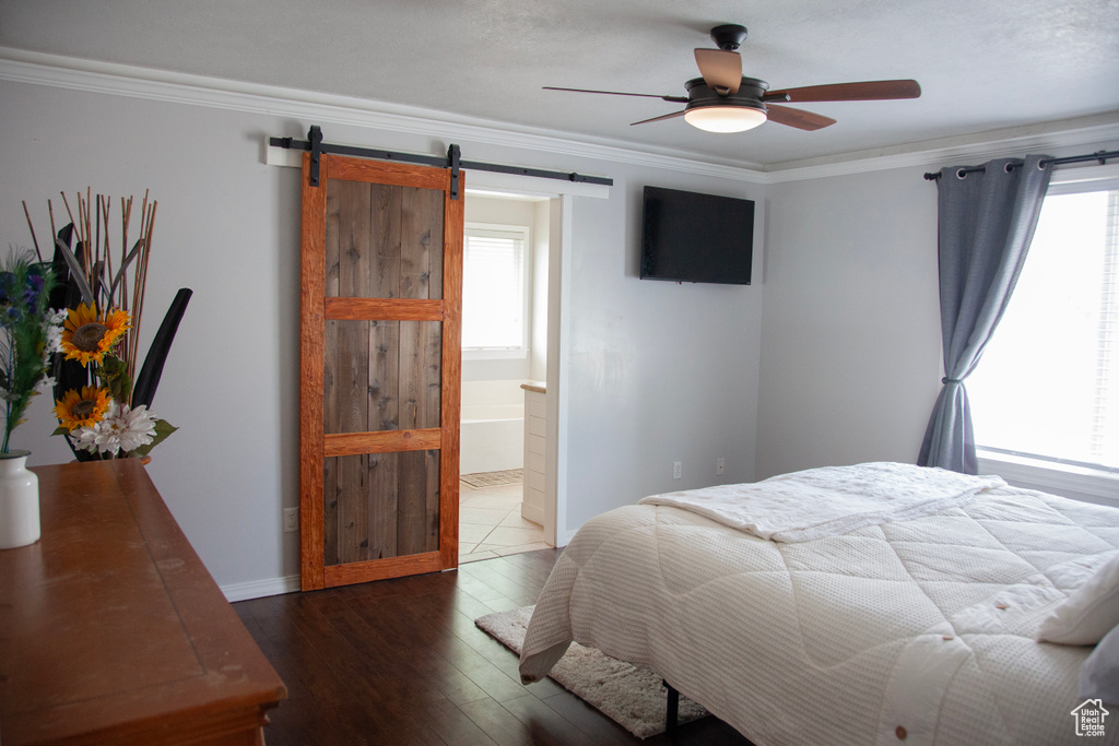 Bedroom with crown molding, multiple windows, and a barn door