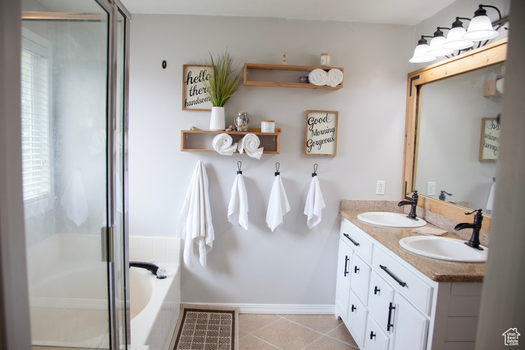 Full bathroom featuring a sink, baseboards, and a healthy amount of sunlight