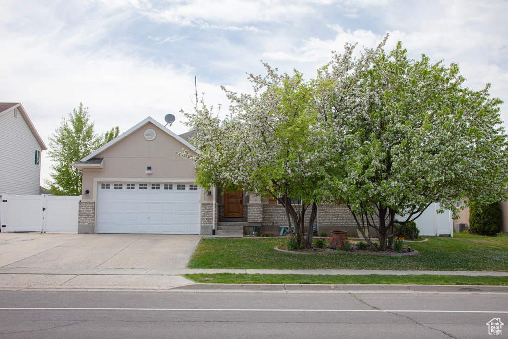 View of front of house featuring a front lawn, driveway, a garage, and a gate