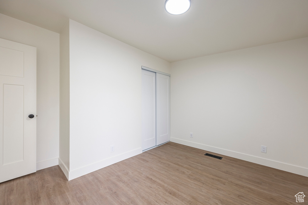 Spare room with visible vents, light wood-type flooring, and baseboards