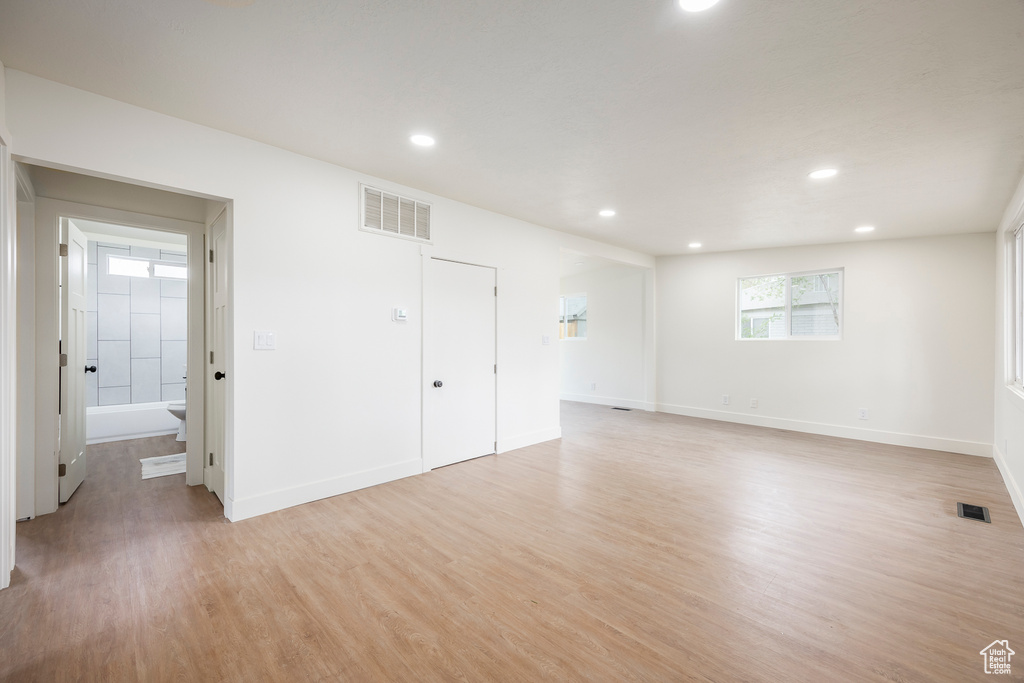 Interior space with baseboards, visible vents, light wood-style flooring, and recessed lighting