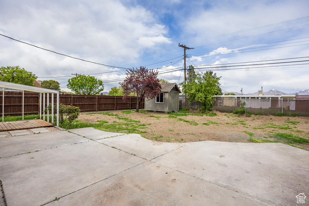View of patio featuring a storage unit, an outbuilding, and a fenced backyard