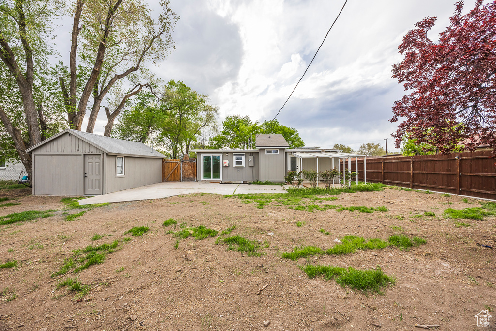Rear view of house featuring a fenced backyard, a patio area, and an outdoor structure