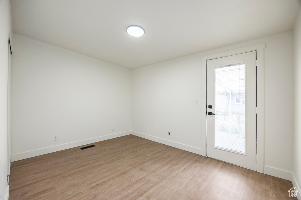 Spare room with visible vents, light wood-type flooring, and baseboards