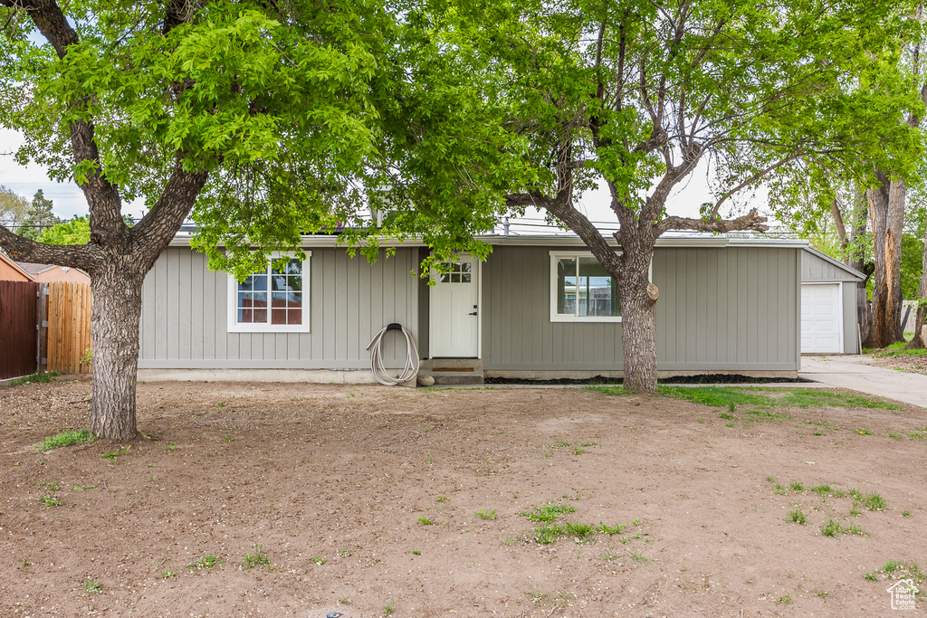 View of front of home with a garage, fence, and driveway