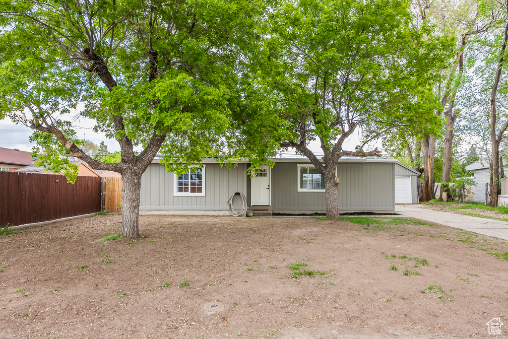 Ranch-style home with driveway, a garage, and fence