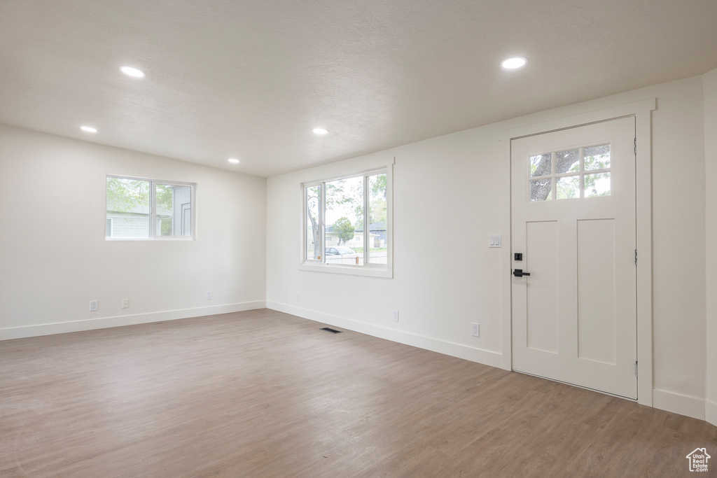 Foyer featuring plenty of natural light, recessed lighting, baseboards, and light wood-type flooring