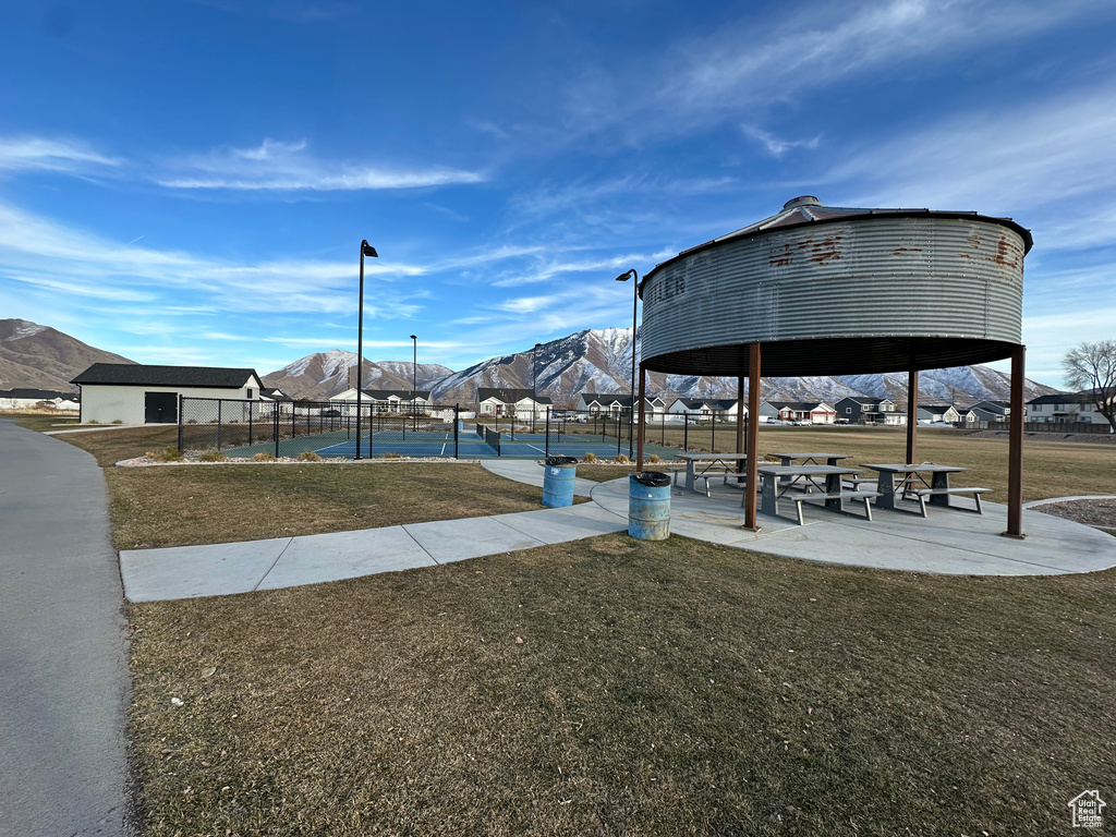 View of property's community with fence, a tennis court, a gazebo, a mountain view, and a yard