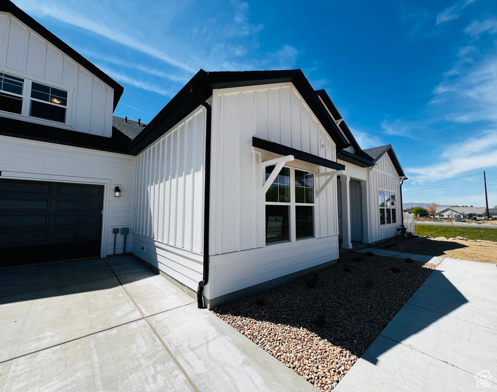 View of home\'s exterior featuring a garage, board and batten siding, and concrete driveway