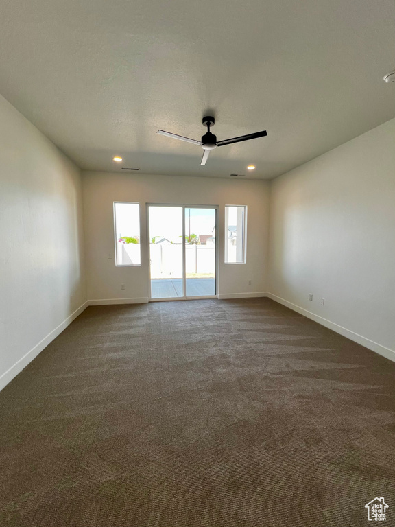 Unfurnished room featuring baseboards, recessed lighting, dark carpet, and ceiling fan