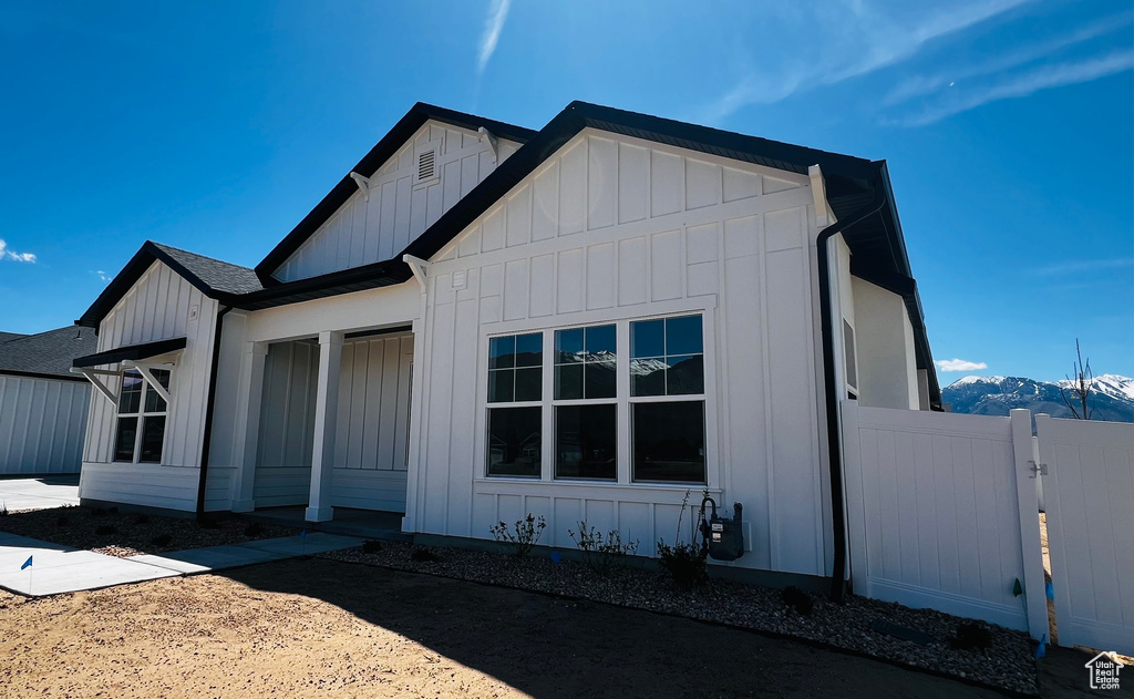 View of front of house with fence and board and batten siding