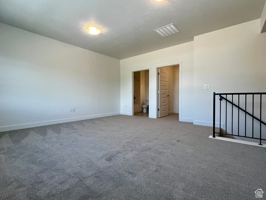Carpeted empty room featuring baseboards