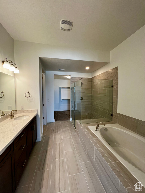 Full bath with a bath, visible vents, a shower stall, and vanity