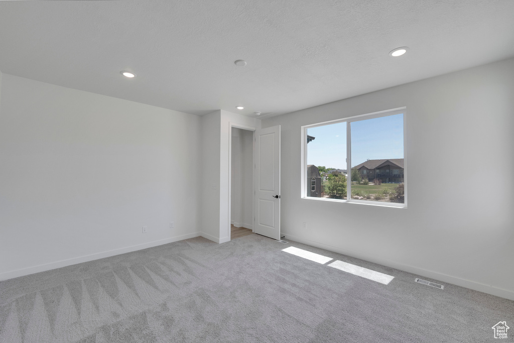 Carpeted empty room featuring recessed lighting and baseboards