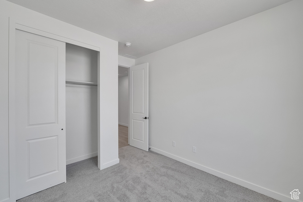 Unfurnished bedroom with carpet flooring and a closet