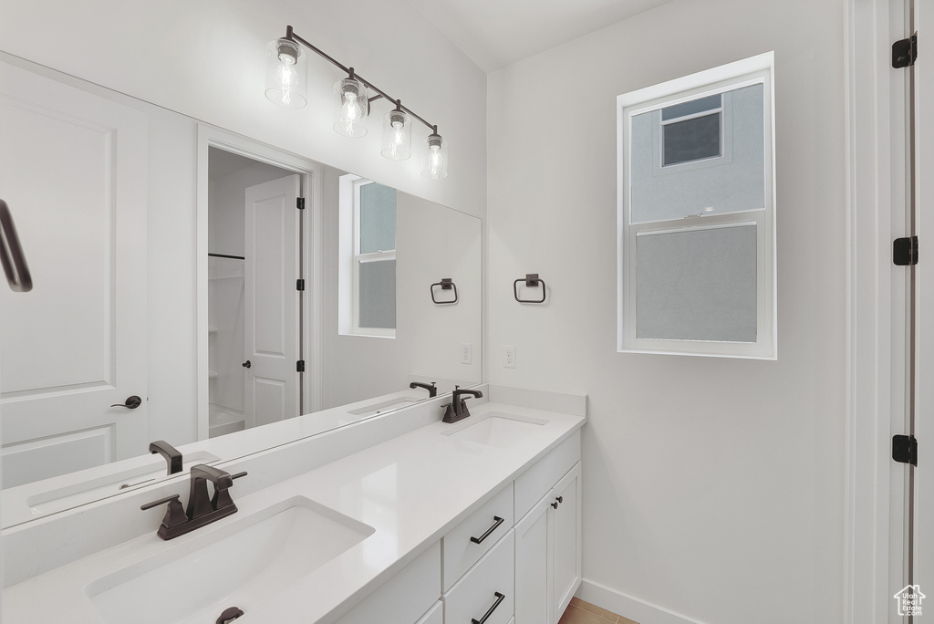 Bathroom featuring double vanity and baseboards