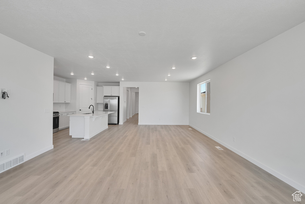 Unfurnished living room featuring recessed lighting and light wood-type flooring