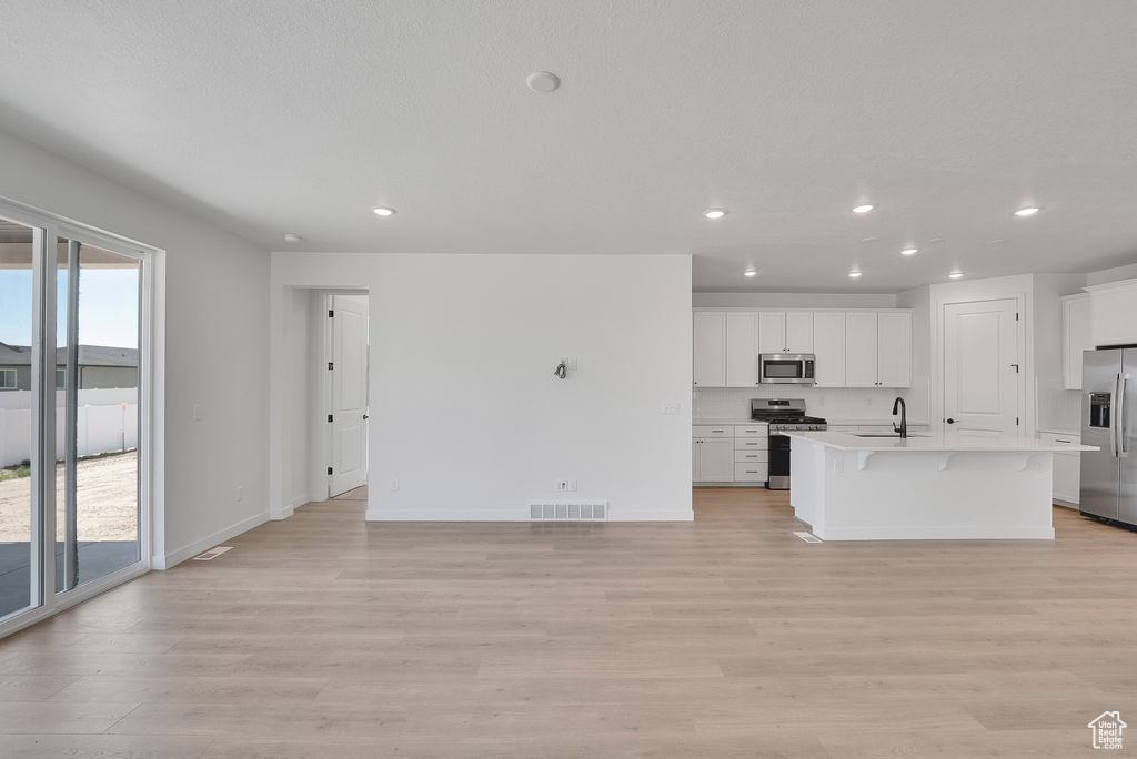 Unfurnished living room with light wood-type flooring and recessed lighting