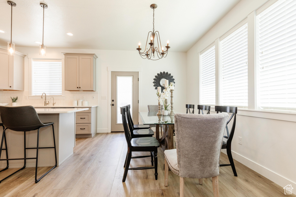 Dining space featuring recessed lighting, baseboards, light wood finished floors, and a notable chandelier
