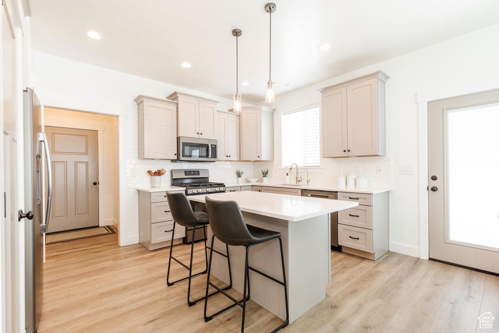 Kitchen with tasteful backsplash, a kitchen breakfast bar, appliances with stainless steel finishes, and a sink