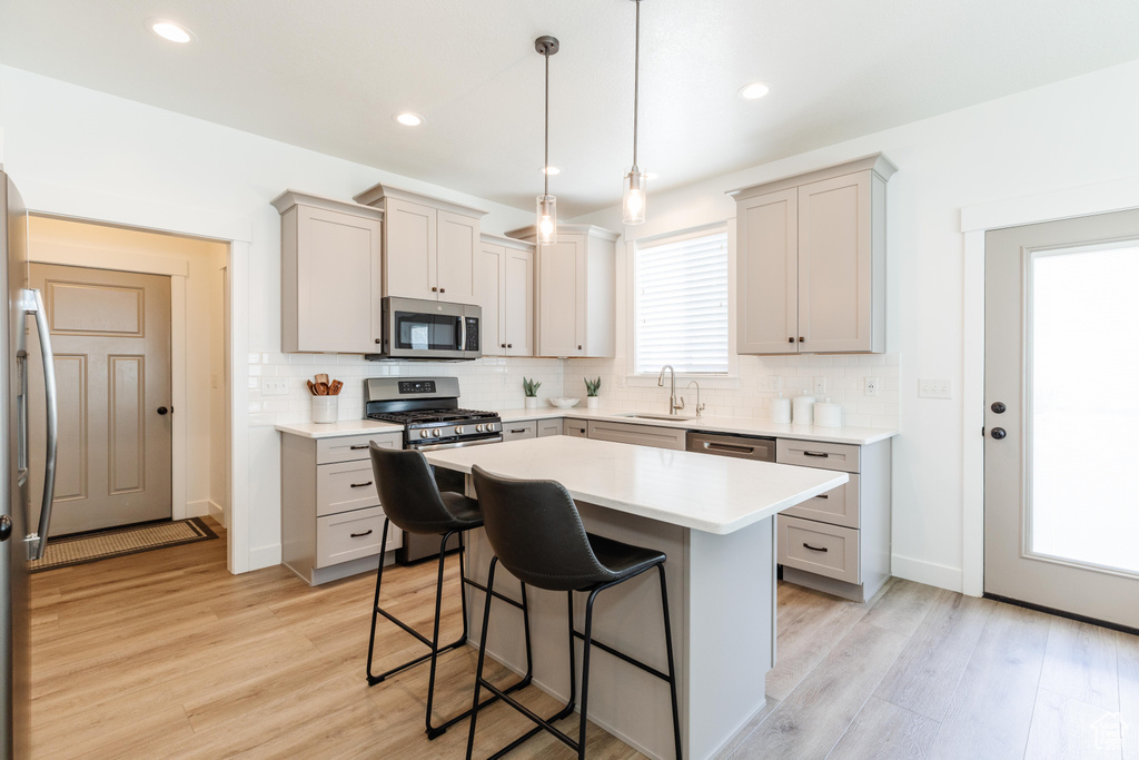 Kitchen with stainless steel appliances, tasteful backsplash, a sink, and a kitchen bar