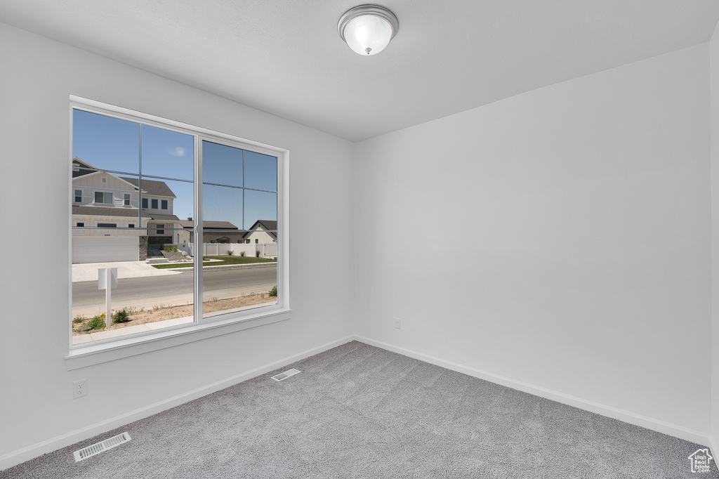 Spare room with carpet and baseboards