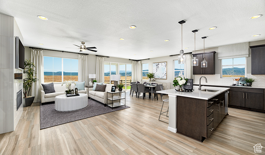 Living area with recessed lighting, ceiling fan, a textured ceiling, and light wood-style flooring