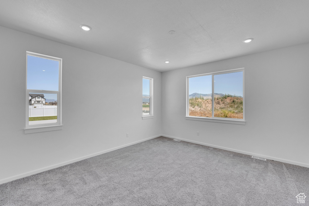 Carpeted empty room featuring recessed lighting