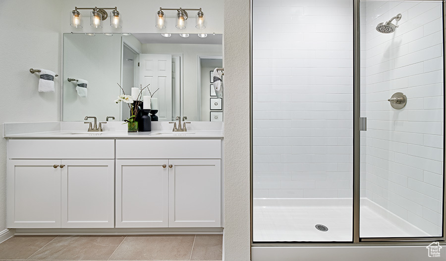 Full bath with tiled shower and a sink