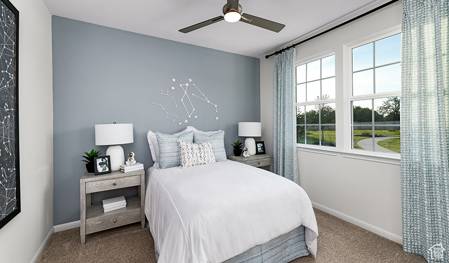 Carpeted bedroom with a ceiling fan and baseboards